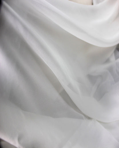 White 10 momme mulberry silk chiffon arranged in broad flowing folds, showing its lightweight movement and airy fluid drape.