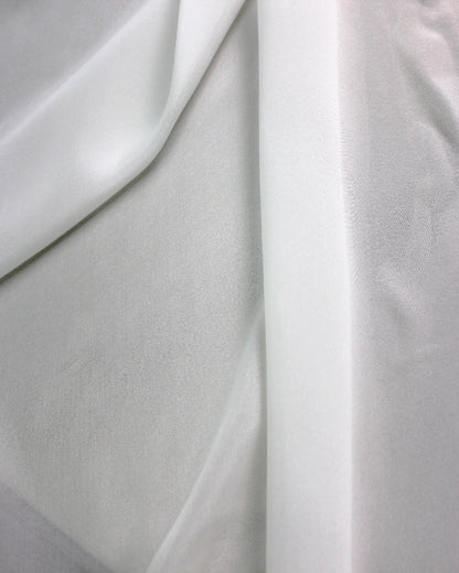 Layered white 10 momme silk chiffon showing translucent overlap, fine woven texture and lightweight sheer construction.
