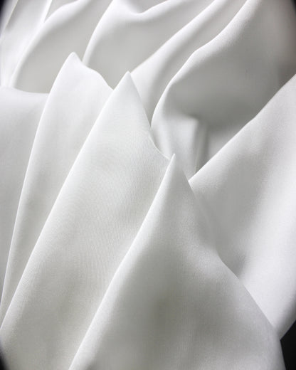 White 12 momme silk Habotai formed into sculpted folds, showing its smooth surface and softly structured lightweight body.