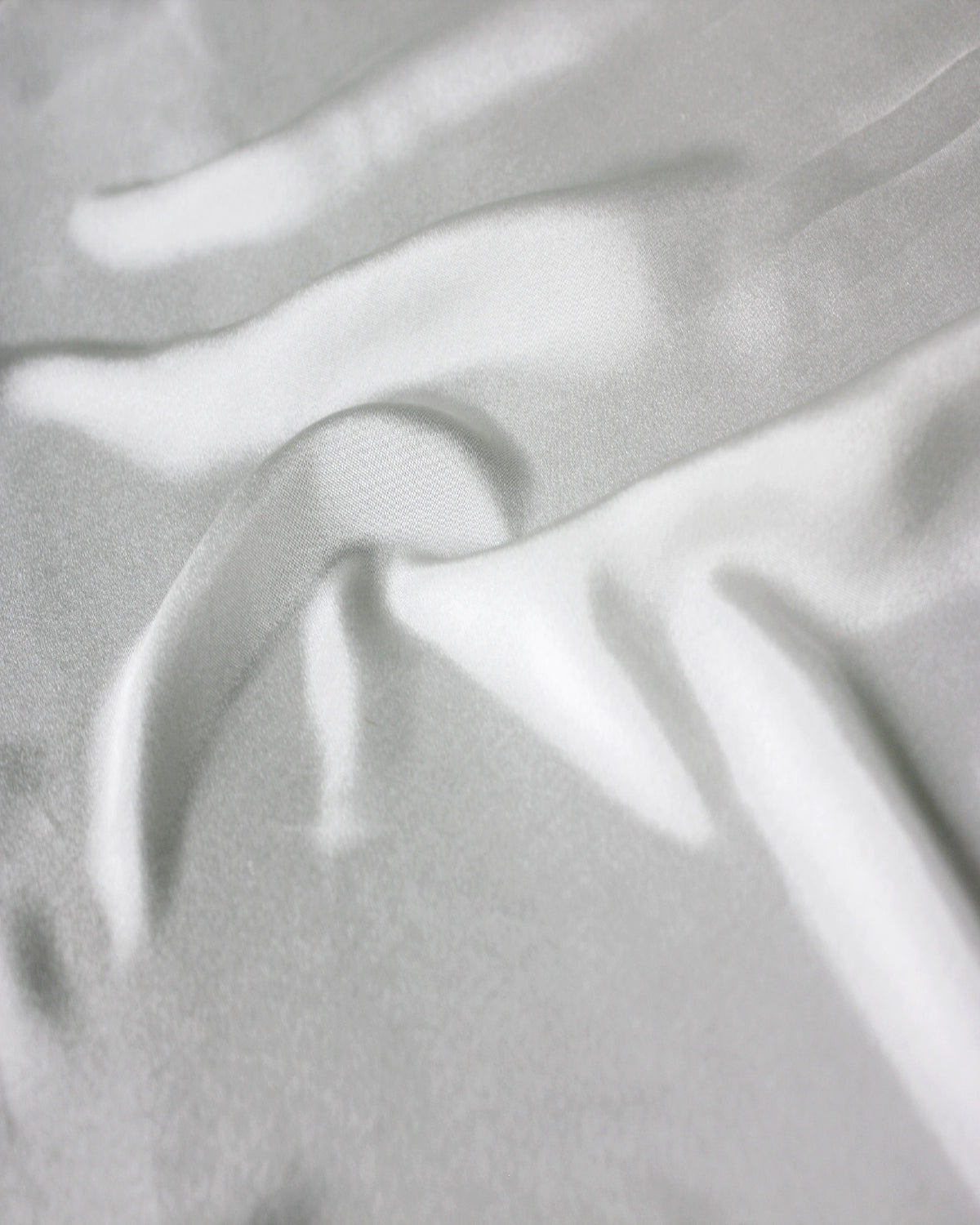 Close-up of white 12 momme silk Habotai showing its fine plain-weave surface and soft natural lustre.