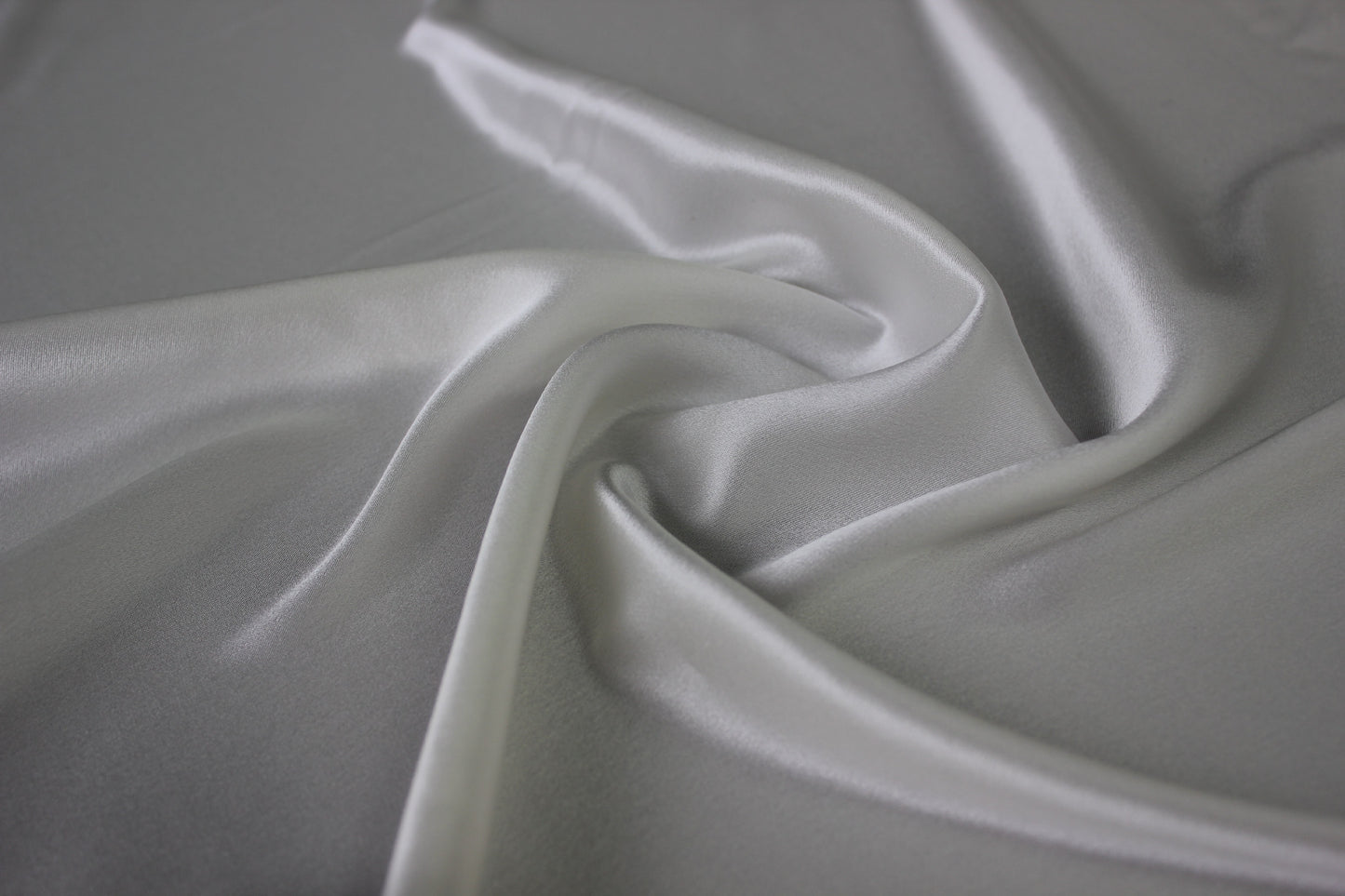 MingSilk 19 momme mulberry silk charmeuse in bleached white with fluid folds and soft satin lustre.