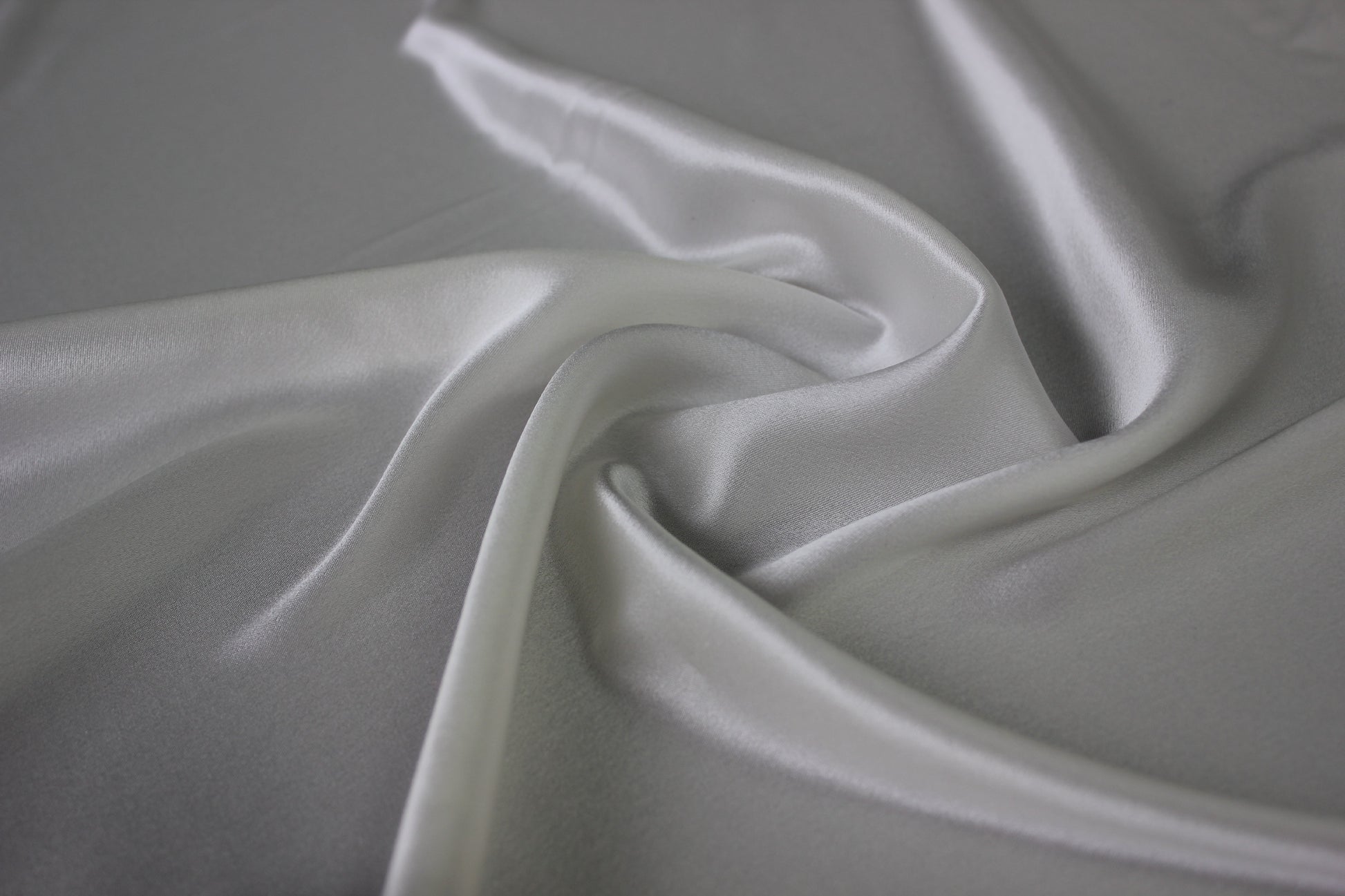 MingSilk 19 momme mulberry silk charmeuse in bleached white with fluid folds and soft satin lustre.
