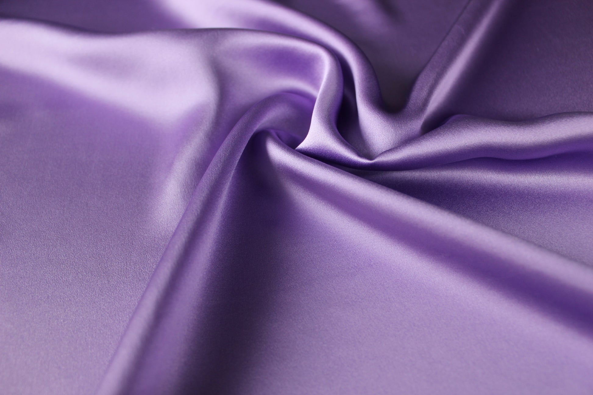 Lavender purple 19 momme mulberry silk charmeuse fabric with fluid folds and a smooth satin lustre.