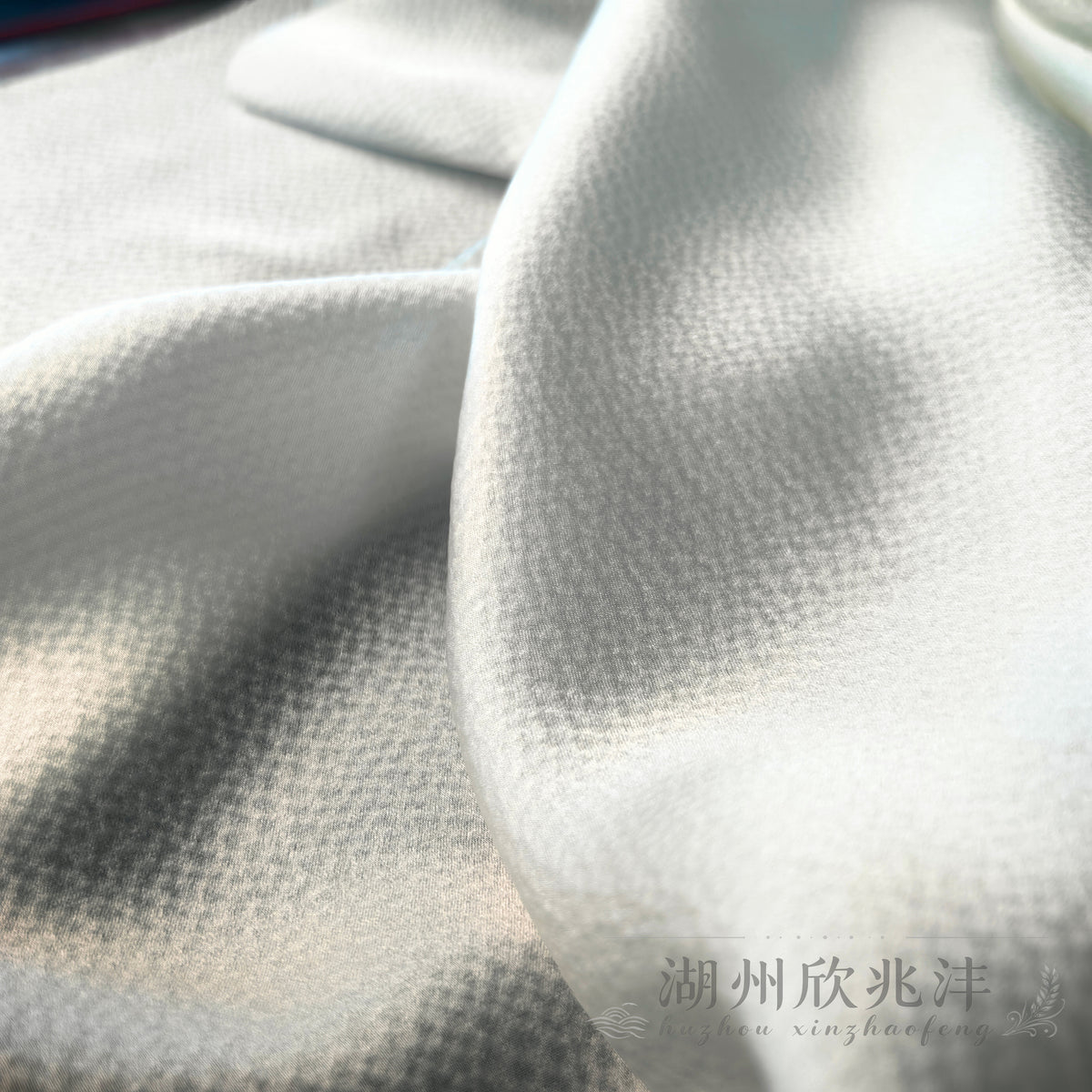 19 momme MingSilk pearl satin arranged in soft flowing folds to show its supple drape and textured silk surface.
