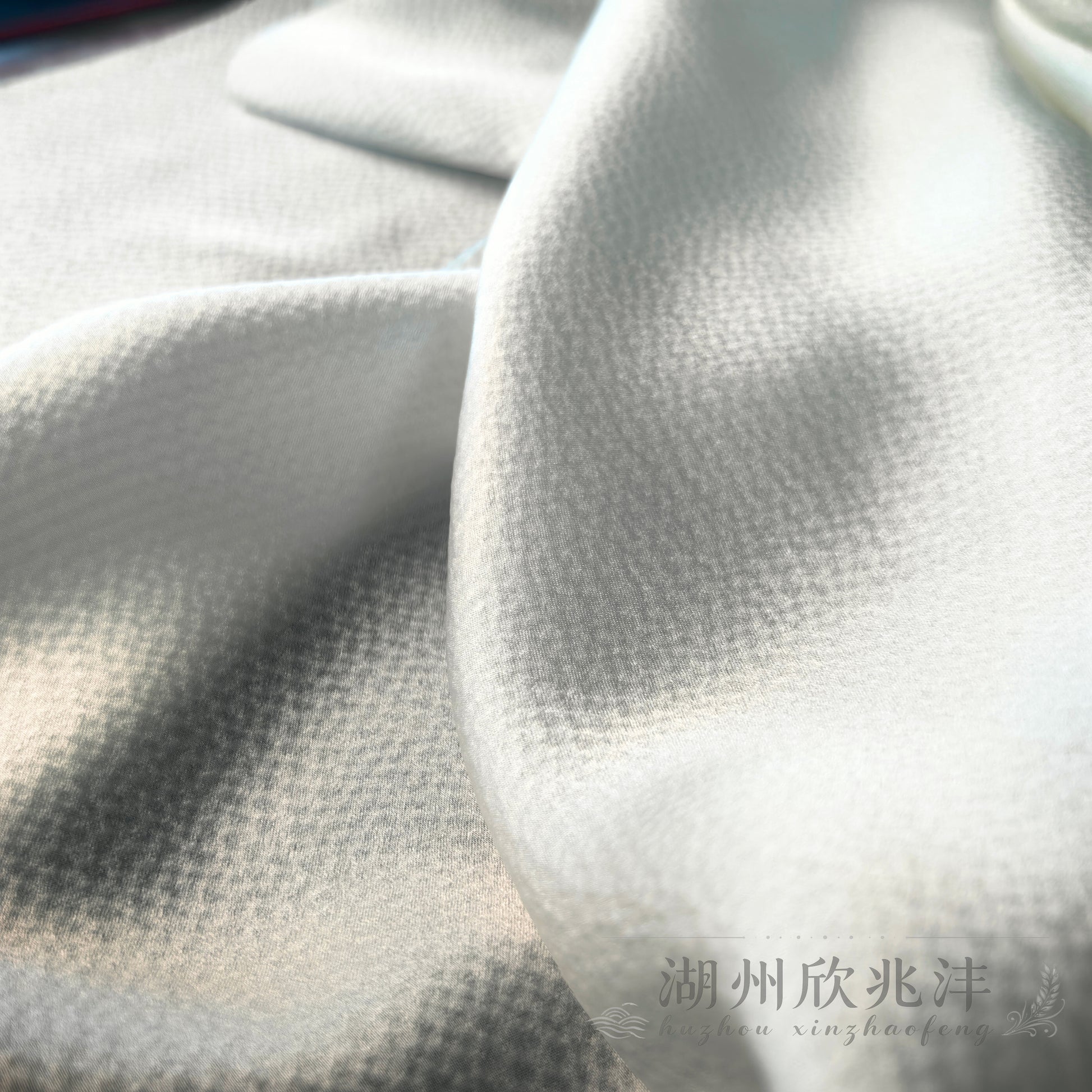 19 momme MingSilk pearl satin arranged in soft flowing folds to show its supple drape and textured silk surface.