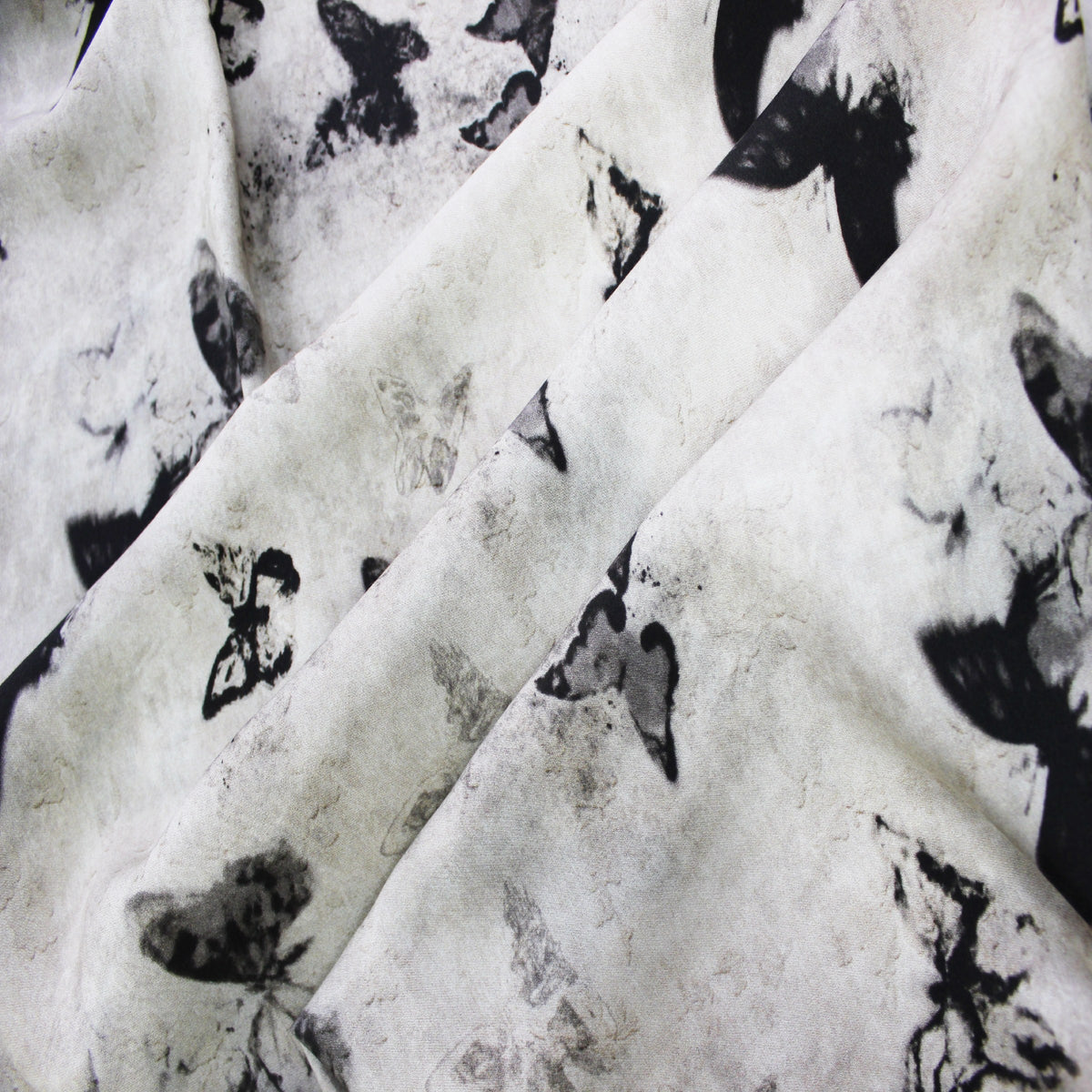 Ink butterfly print silk rayon fabric swirled to show lightweight flow and soft drape