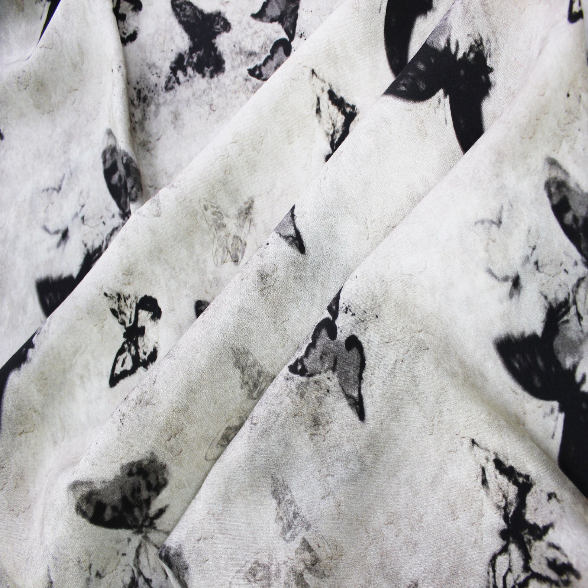 Ink butterfly print silk rayon fabric swirled to show lightweight flow and soft drape