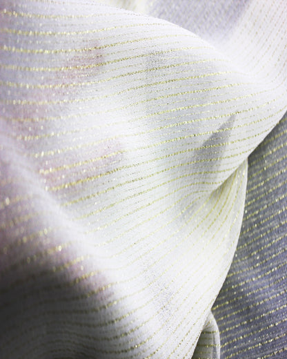 Detail of white silk Yoryu fabric showing reflective gold metallic stripe yarns under directional light.