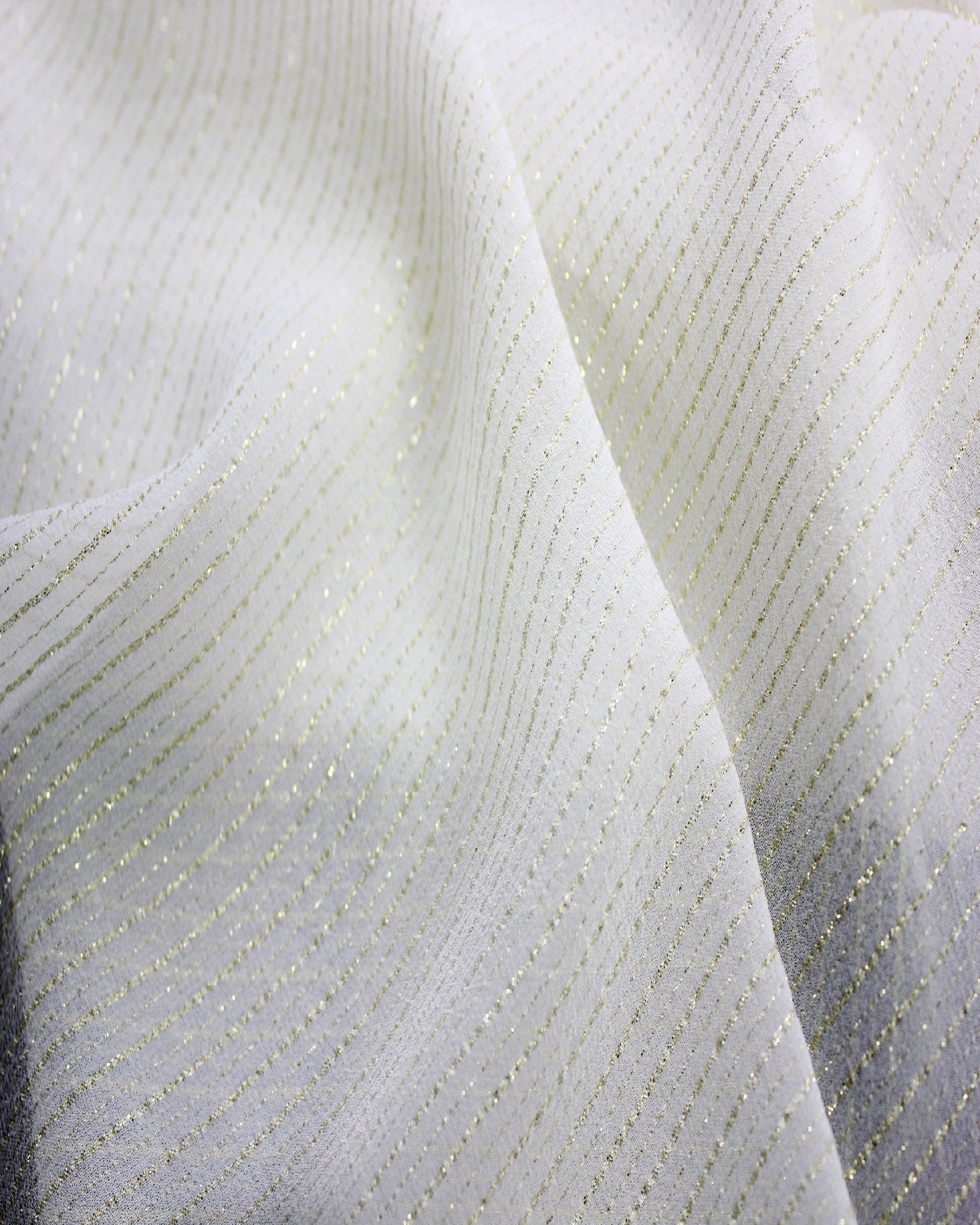 Close-up of 9 momme silk Yoryu showing fine parallel gold metallic stripes and a lightweight textured surface.