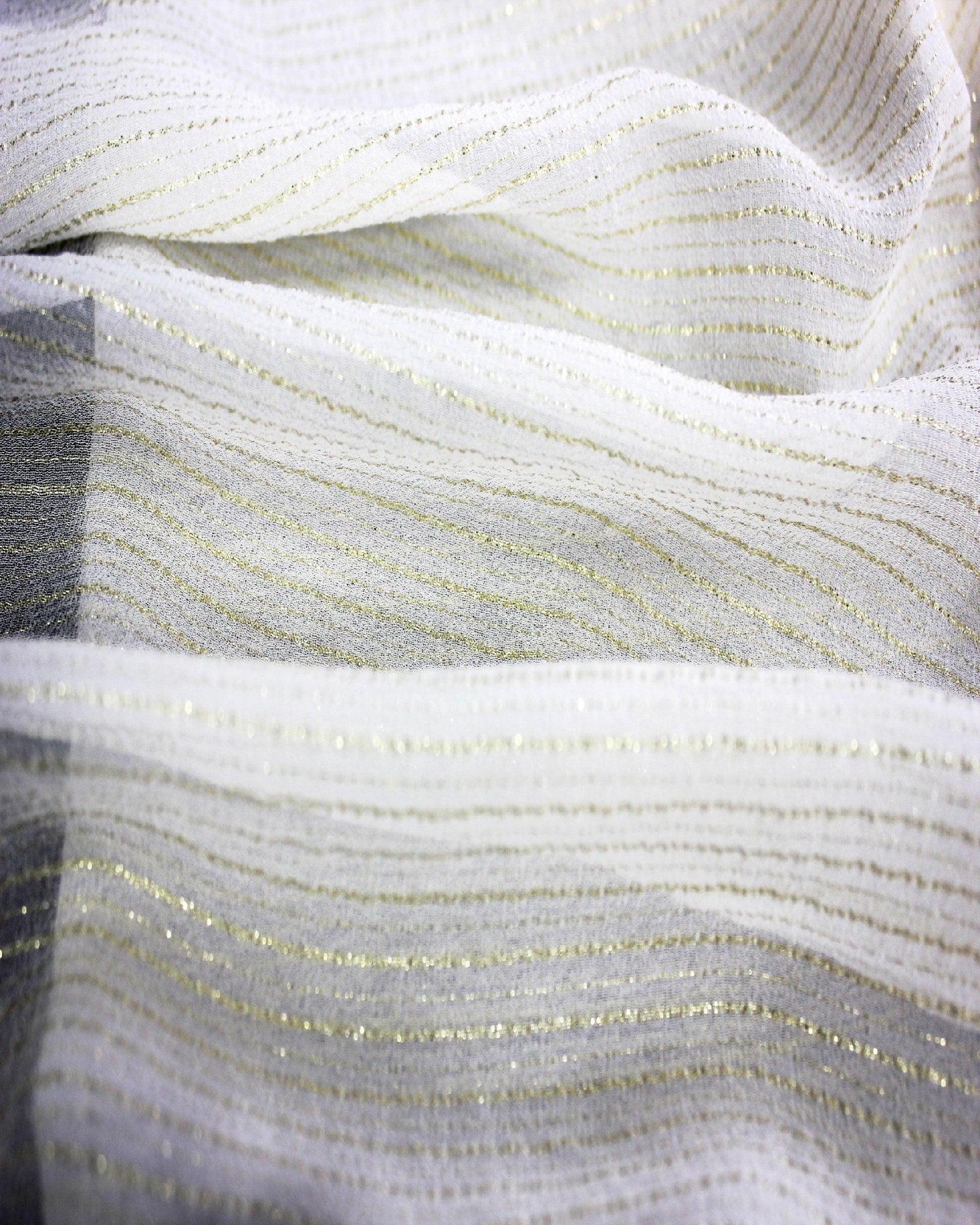 Layered silk Yoryu fabric with fine gold metallic stripes showing its subtle crinkle texture and semi-sheer construction.
