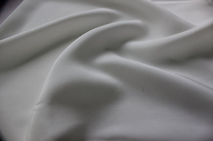 Close view of bleached white MingSilk silk charmeuse showing a smooth fine surface and soft drape.