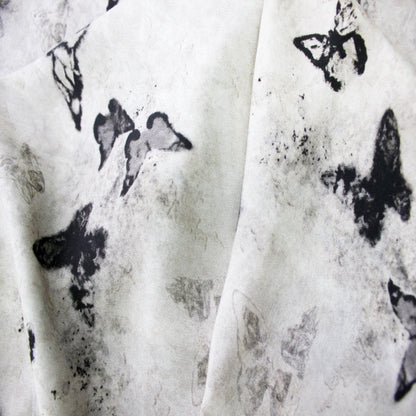 Macro close-up view of ink wash butterfly print and fine texture on silk rayon fabric