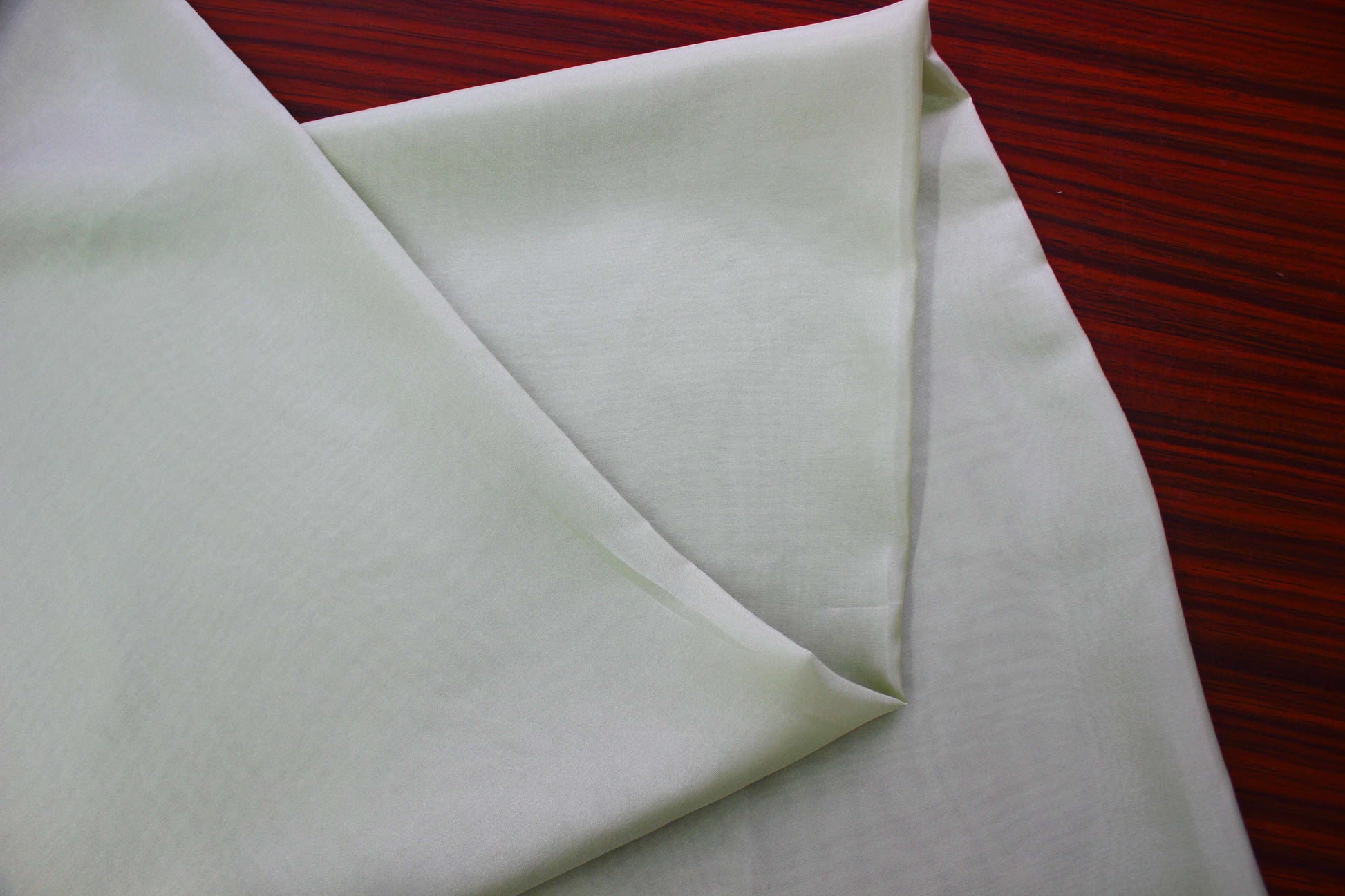 Luxury light green silk fabric draping display for premium fashion garments