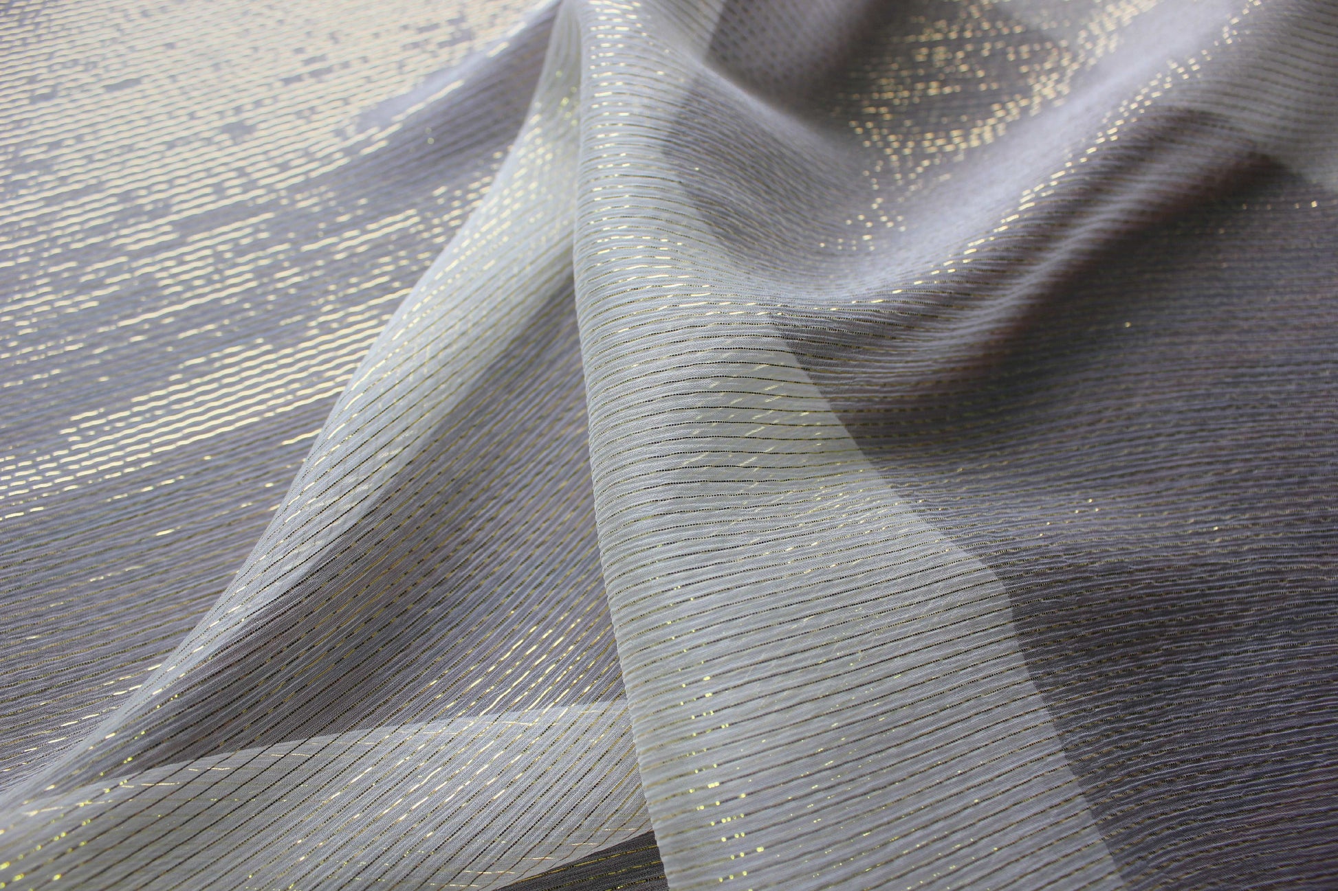 Layered sheer silk Yoryu showing transparency, fine crinkles and gold-tone metallic stripes.