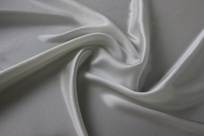 Close-up of MingSilk silk charmeuse showing its smooth satin sheen, pearly highlights and flowing folds.