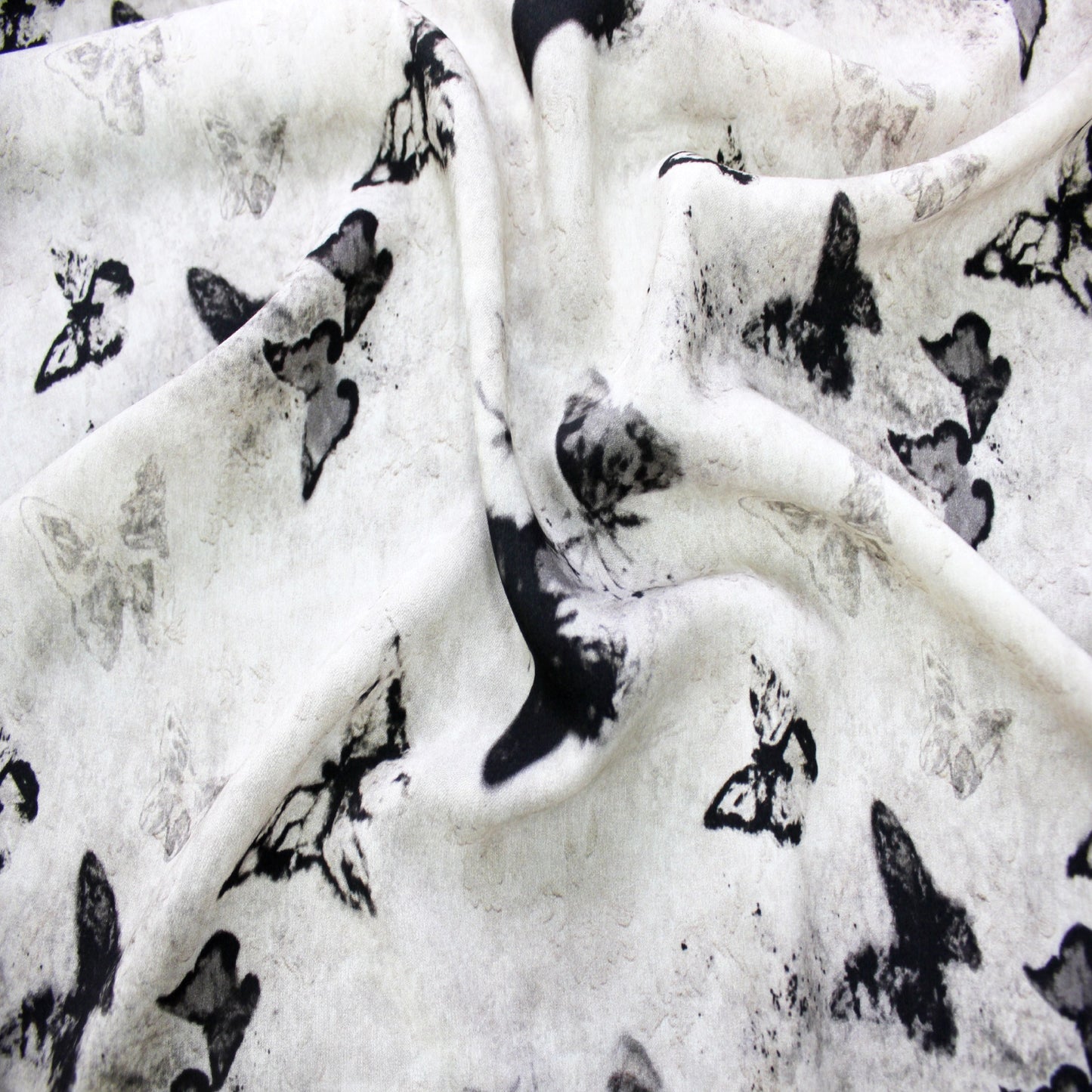 Folded lightweight silk viscose fabric swatch showing multi-layer butterfly pattern display