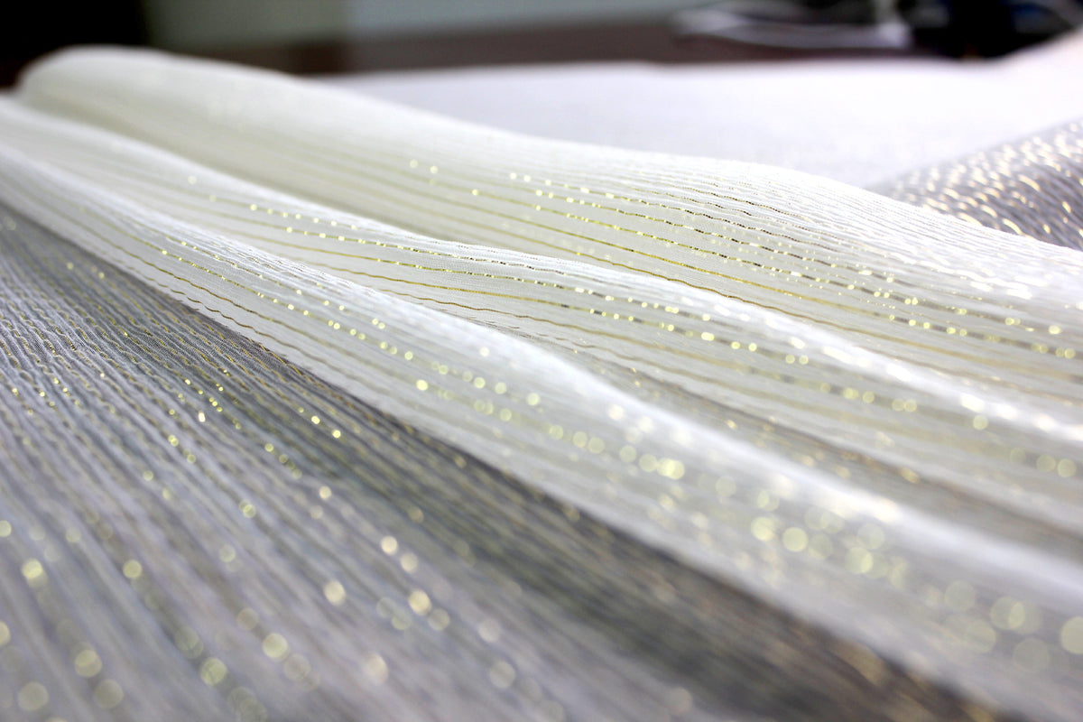 Gold-tone metallic yarns catching light across sheer MingSilk silk Yoryu fabric.