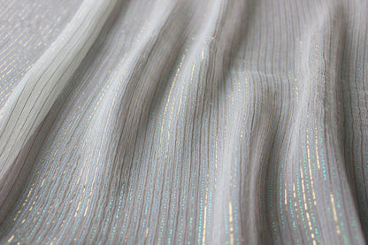 Iridescent gold, aqua and blue-green metallic stripes catching light across MingSilk Yoryu silk.
