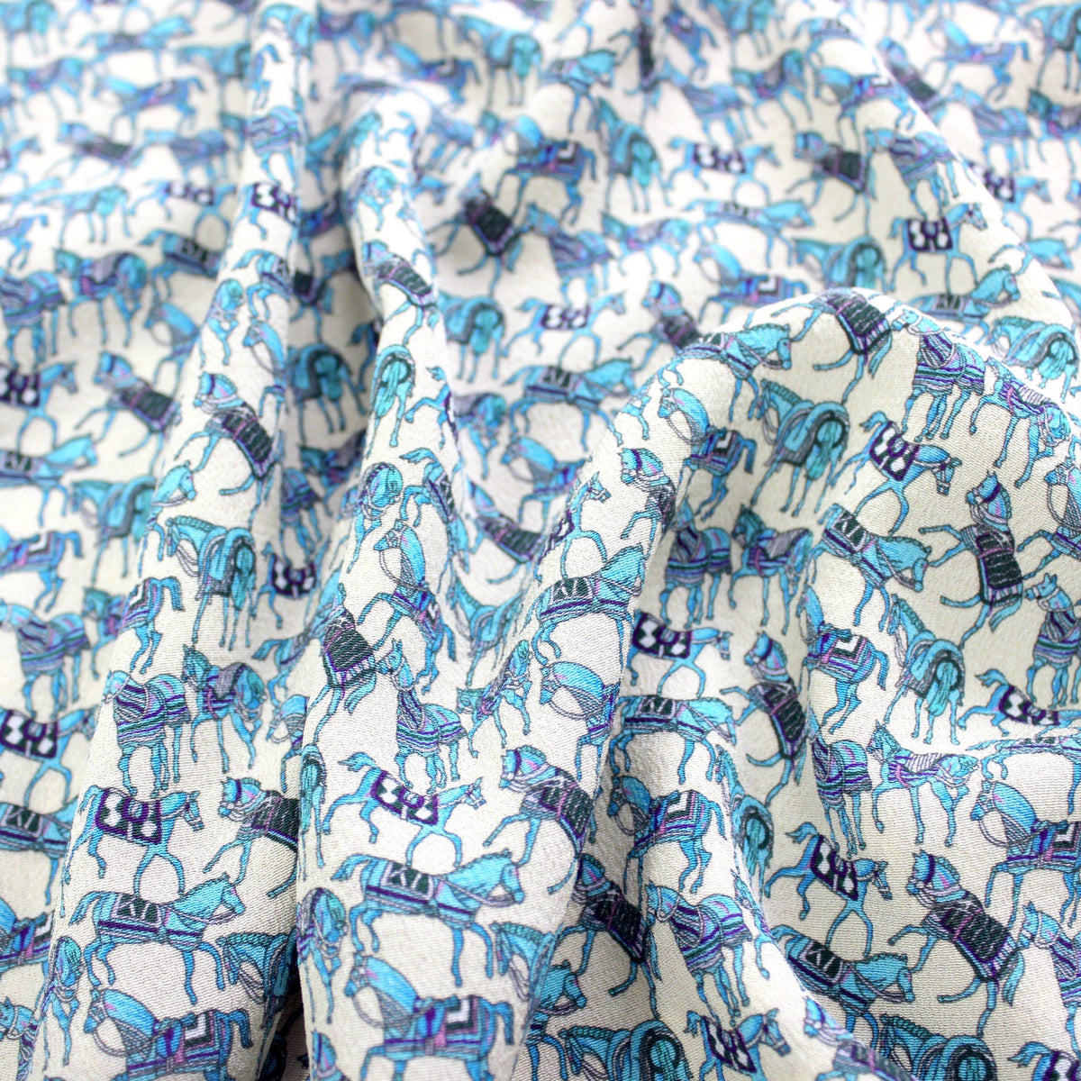 Turquoise horse print mulberry silk fabric showing soft drape and sheen