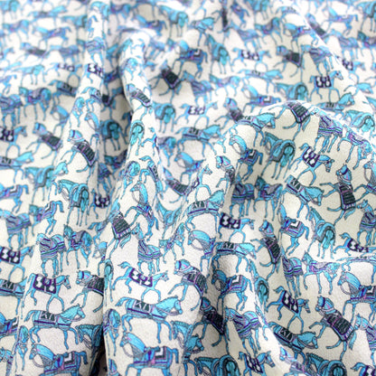 Turquoise horse print mulberry silk fabric showing soft drape and sheen